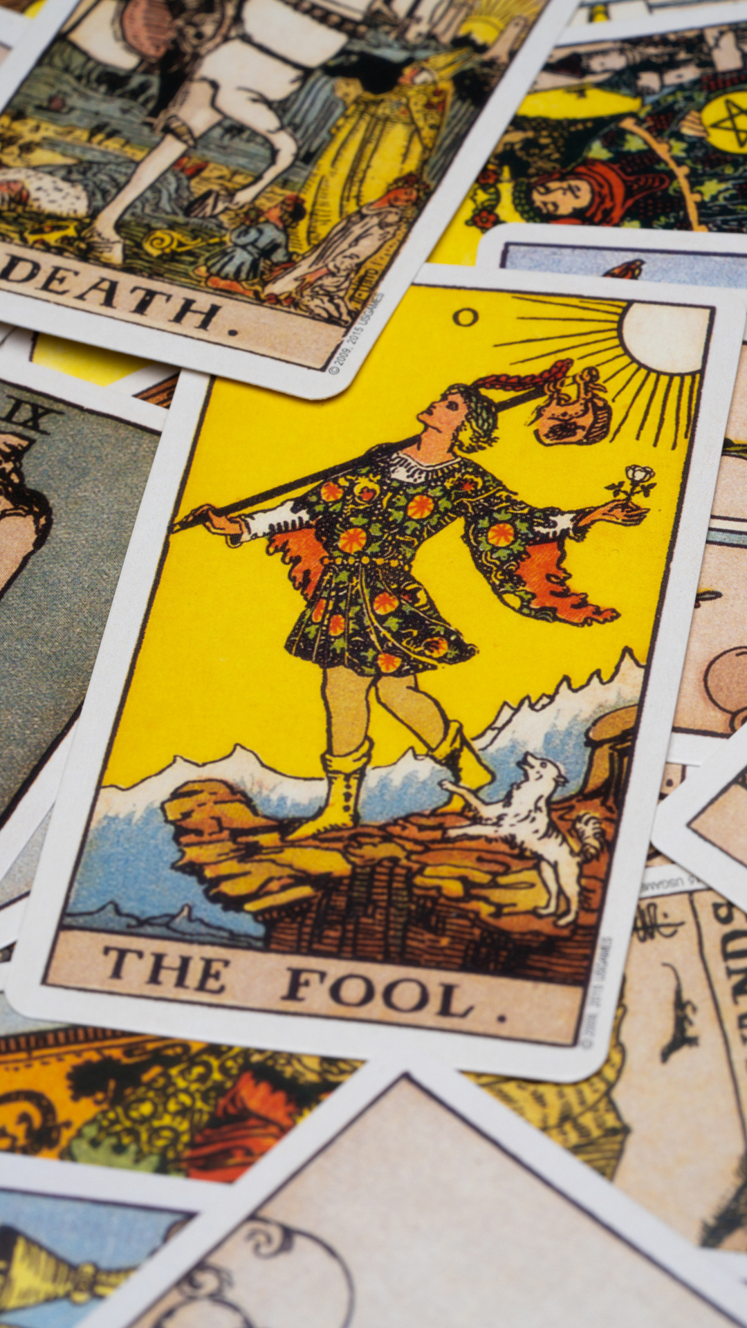 En utspridd hög av tarotkort där bland annat The Fool och Death tarotkorten syns.